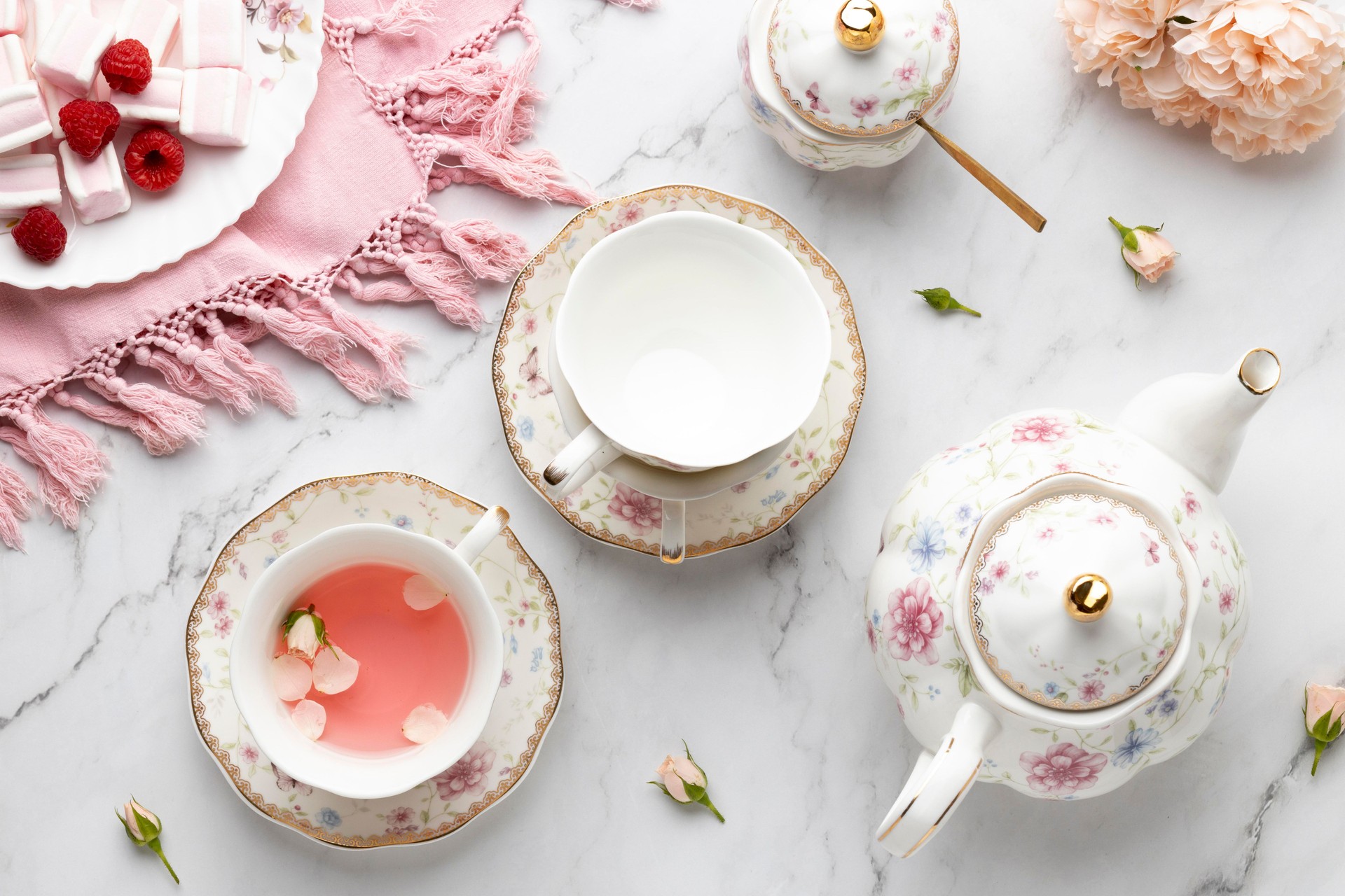 Top view of an elegant tea party or Valentine's composition, with sweets and floral glassware